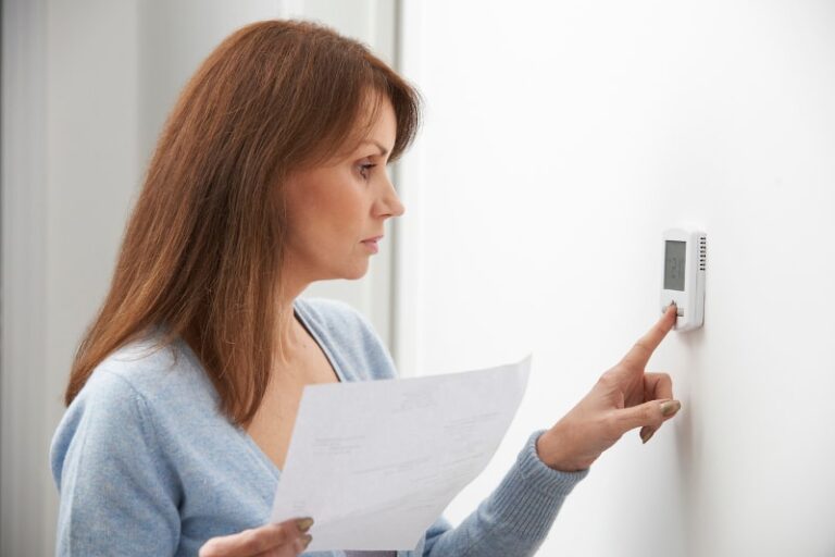 Woman Adjusting Smart Thermostat Screen